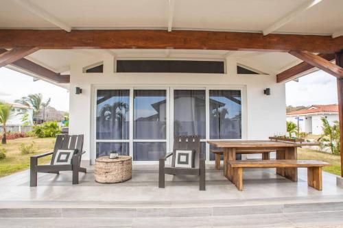 a patio with a wooden table and chairs at Steps From Ocean Couple's Getaway Private Villa in Playa Venao
