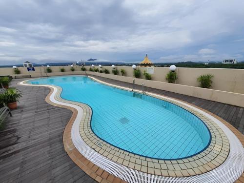 a large swimming pool on top of a building at Cozzzy hut Riverbank Suites Kuching with spectacular River view in Kuching