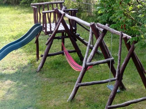 a playground with two swings and a slide at Agroturystyka Przy Siole Budy in Białowieża