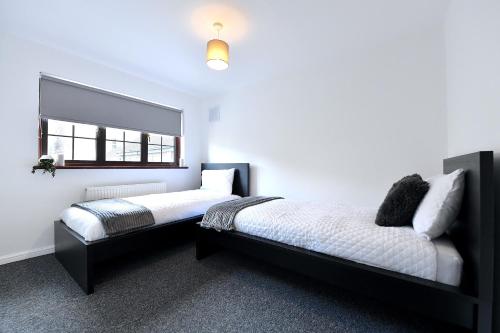 a bedroom with two beds and a window at Large home near central London in London