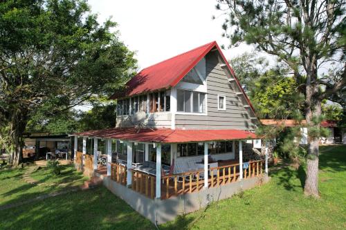 a large house with a red roof on a yard at La Dama de los vientos in Cerro Azul