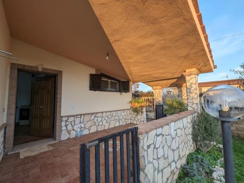 une maison avec un mur en pierre et une terrasse couverte dans l'établissement La Villetta del Gelso bianco, à Aprilia