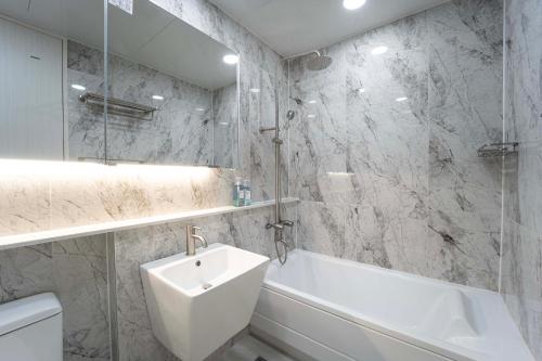 a bathroom with a white tub and a sink and a bath tub at Boutique hotel with outdoor barbeque #pet friendly in Incheon