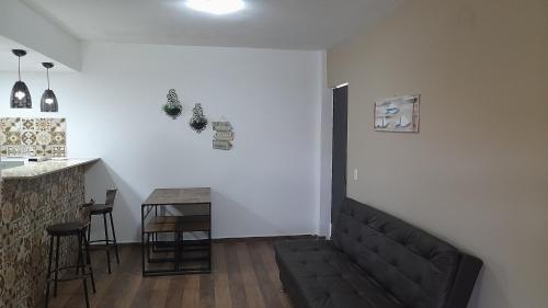 sala de estar con sofá negro y bar en Arraial do Cabo - Praia do Pontal, en Arraial do Cabo