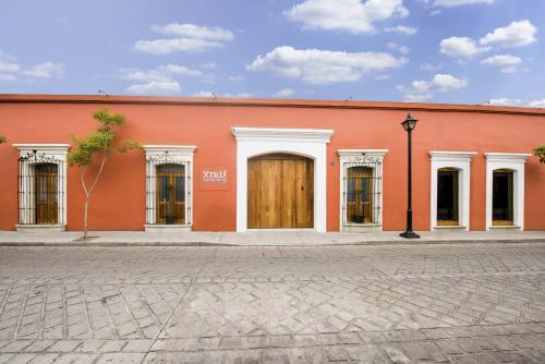 a red brick building with a red door at XTILU Hotel - Adults only - in Oaxaca City