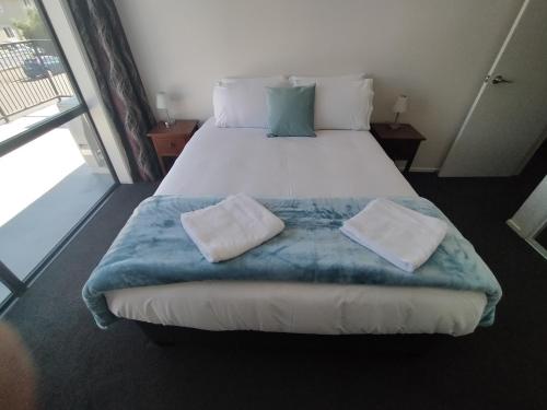 um quarto com uma cama grande com duas almofadas em 117 Leith St em Dunedin