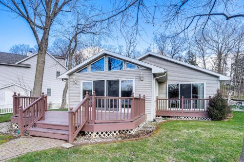 a home with a large porch and a deck at House on Paw Paw Lake with Private Dock! in Coloma