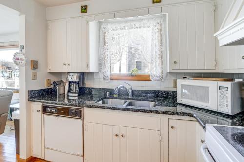 a kitchen with white cabinets and a sink and a window at House on Paw Paw Lake with Private Dock! in Coloma