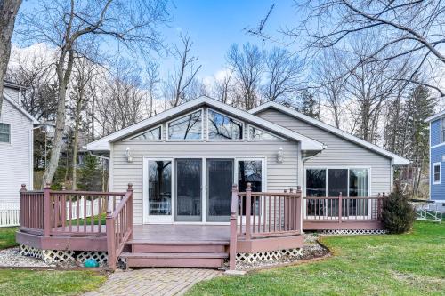 a house with a large porch with a deck at House on Paw Paw Lake with Private Dock! in Coloma