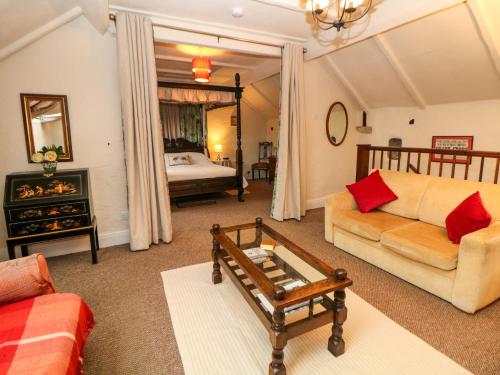 een woonkamer met een bank en een tafel bij Shippon Cottage in Castleton