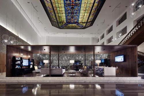 a lobby with a large stained glass ceiling and a living room at Wyndham Monterrey Ambassador Centro in Monterrey