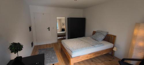a small bedroom with a bed and a mirror at Fresh renovated. 3 Róoms. Central Leonberg. Private parking spot. in Leonberg