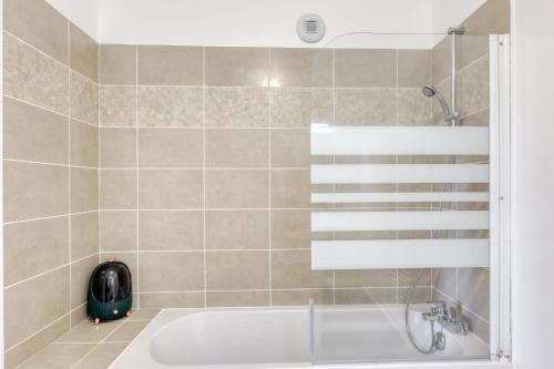 uma casa de banho com banheira e chuveiro em Appart cosy à 10 min à pied du métro Pablo Picasso em Bobigny
