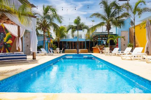 a swimming pool with chairs and palm trees in a resort at Coco Beach Hotel - Rooftop & Beach Club in Cartagena de Indias