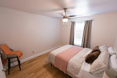 a bedroom with a bed and a chair and a window at ※ Cul-de-Sac Haven, Stylish & Tranquil ~ King Beds in Forney
