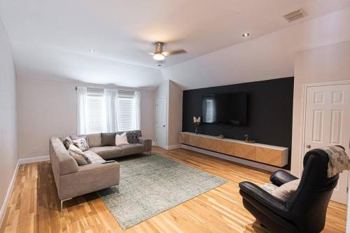 een woonkamer met een bank en een flatscreen-tv bij ※ Cul-de-Sac Haven, Stylish & Tranquil ~ King Beds in Forney