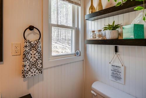 a bathroom with a toilet and a window at Inviting Alton Bay Home Near Lake Winnipesaukee! in Alton Bay