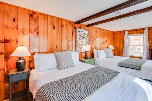 two beds in a room with wooden walls at Inviting Alton Bay Home Near Lake Winnipesaukee! in Alton Bay