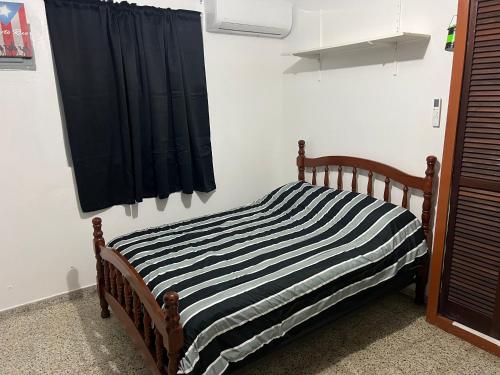 a bed in a room with a black curtain at Coqui del corazón Guest House in Hatillo