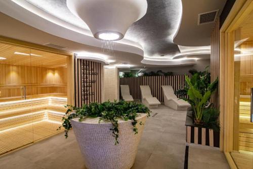 a lobby with a large pot with plants in it at Adoro Titova Vila in Zlatibor