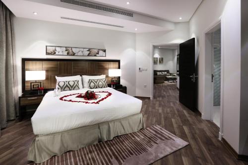 a large bedroom with a large white bed and a room at Duset Suites in Riyadh