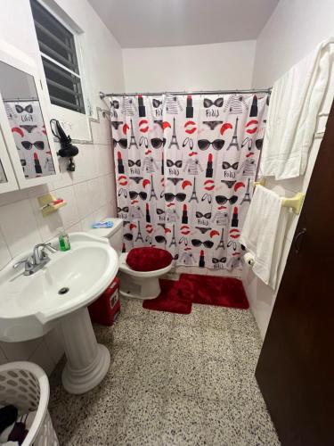 a bathroom with a toilet and a shower curtain at Coqui del corazón Guest House in Hatillo