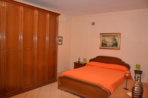 a bedroom with a bed and a large wooden cabinet at Low Cost La Meridiana in Zafferana Etnea