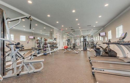 a gym with treadmills and machines in a room at Maggie's Cozy Corner in Wimauma