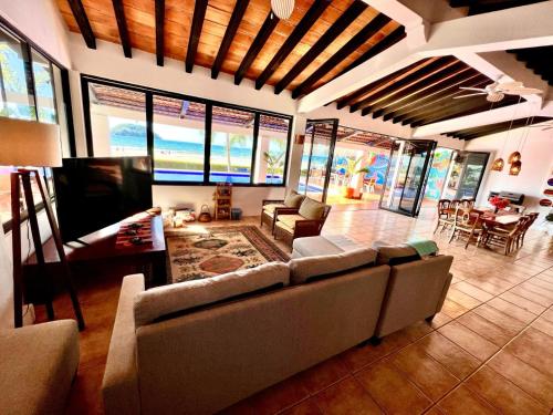 sala de estar con sofá, mesa y sillas en Beachfront Villa en Rincon de Guayabitos