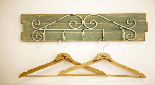 two wooden hangers hanging from a metal rack at Casa Recanto da Horta - Casas com EnCanto in Reguengos de Monsaraz
