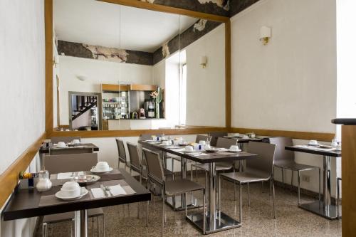 ein Restaurant mit Tischen und Stühlen in einem Zimmer in der Unterkunft Hotel Cervia in Rom