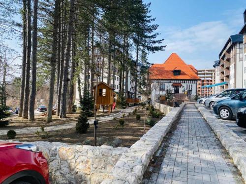 a street with a house and a stone wall at Adoro Titova Vila in Zlatibor