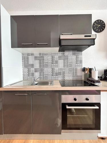 une cuisine avec un évier et une cuisinière dans l'établissement Studio MAJA proche des plages + parking, à Saint-Nazaire