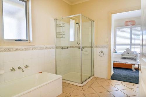 a bathroom with a shower and a bath tub at Charming Cottage, 7 mins walk to the beach and golf! in Torquay