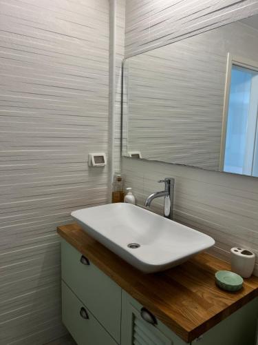 a bathroom with a white sink and a mirror at Saloniky Garden in H̱olon