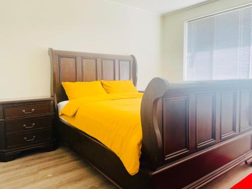 a bedroom with a bed with yellow sheets and a window at House in Thomastown in Melbourne