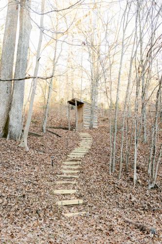 a path in the woods with a small building at Blythe Shoals Base Camp in Cleveland