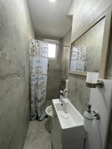 a bathroom with a sink and a toilet and a shower at Center apartment in Gjilan
