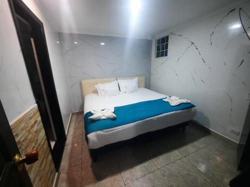 a small bedroom with a bed with towels on it at Hotel Zafiro Boutique in Bogotá