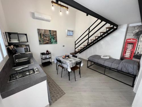 eine Küche und ein Wohnzimmer mit einem Tisch und einer Treppe in der Unterkunft Palermo Hub in Palermo