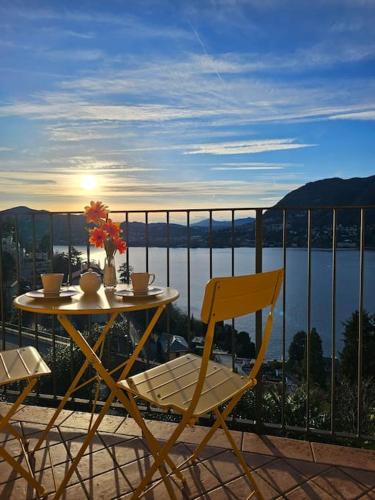 a table and chairs on a balcony with a view of the water at The view Lake ,Appartamento Blevio Fronte lago Como in Blevio