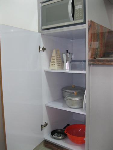 a kitchen with a microwave and some bowls and dishes at Villa La Blanquilla in Pampatar
