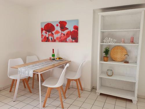 a dining room with a table and white chairs at Charmante Maisonnette-Dachgeschosswohnung in zentraler Lage in Rostock