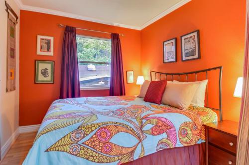 a bedroom with orange walls and a bed and a window at Bonne Chere in Guerneville
