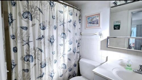 a bathroom with a shower curtain with a toilet and a sink at Paradise awaits you at Key Colony Beach in Key Colony Beach