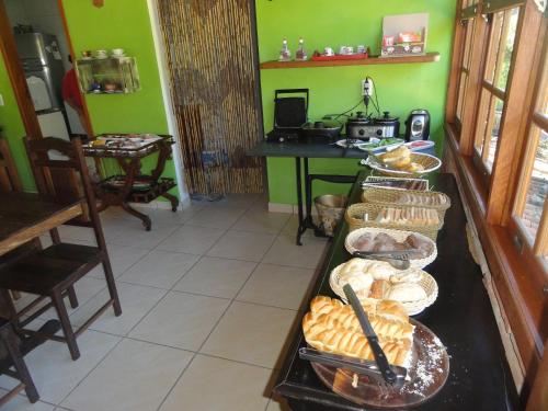 a buffet with bread and pastries on a table at Pousada Chácara do Rio in Lumiar