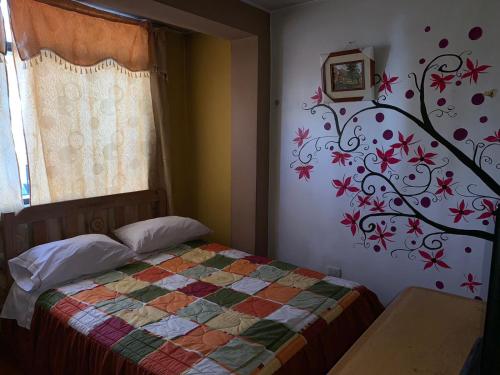 1 dormitorio con 1 cama con un mural en la pared en Hospedaje Luciano en Ayacucho