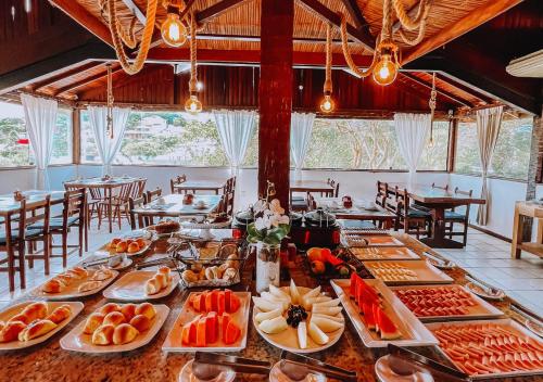 una mesa larga con platos de comida. en Calador Búzios Hotel en Búzios