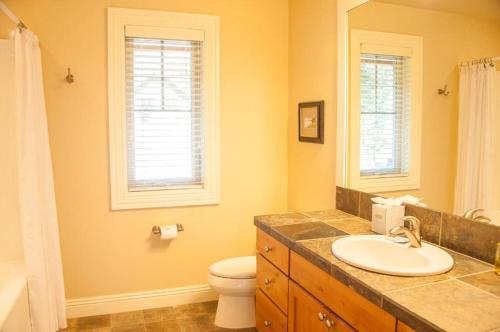 a bathroom with a sink and a toilet and windows at Suncadia 4 Bdrm Home Overlooking Prospector Golf Course in Cle Elum