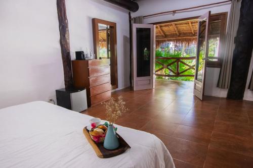 a bedroom with a bed with a tray of food on it at Las Nubes de Holbox in Holbox Island